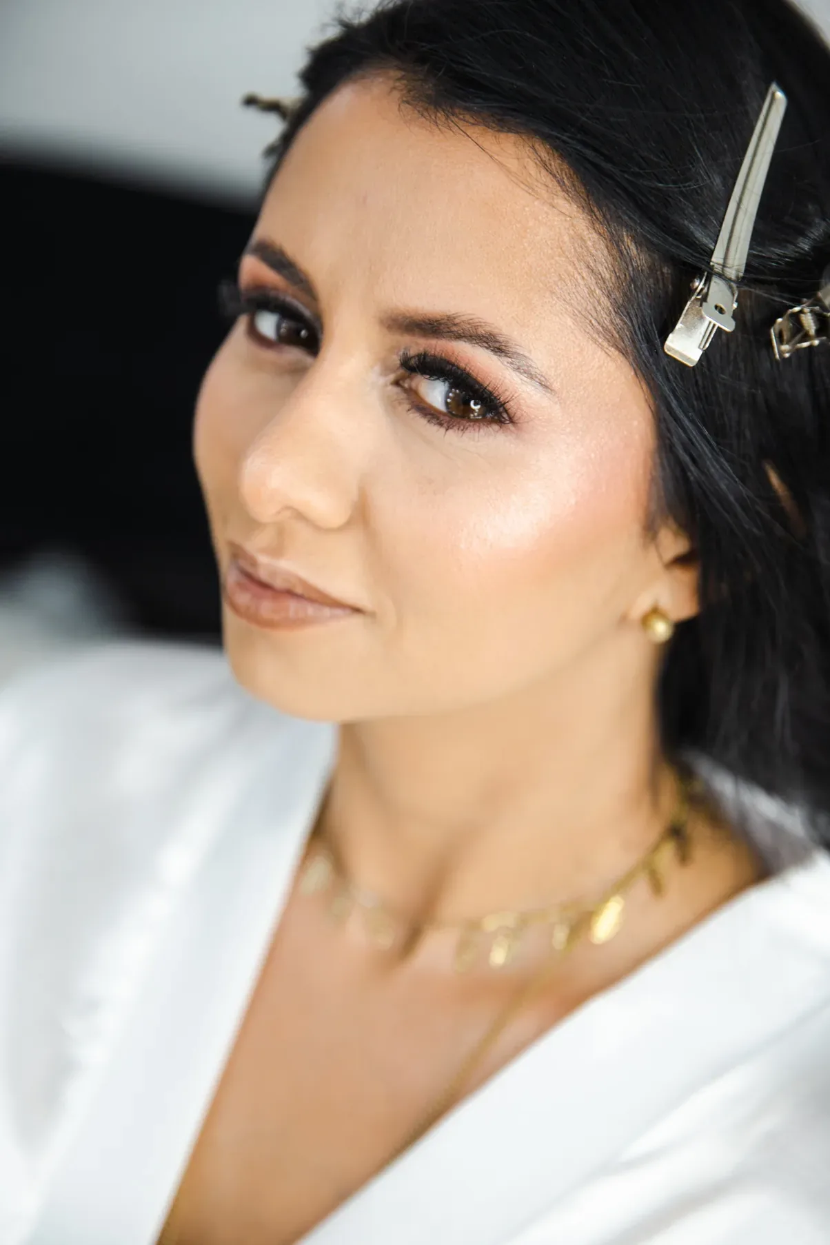 Primer plano del maquillaje de novia de Caro: sombra cobre, pestañas largas, iluminador y labios nude