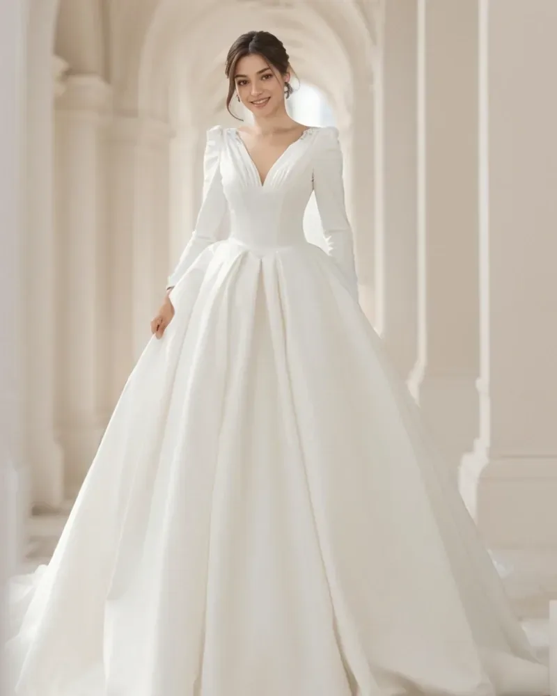 Novia con vestido blanco de falda amplia y escote en V en un interior con arcos.
