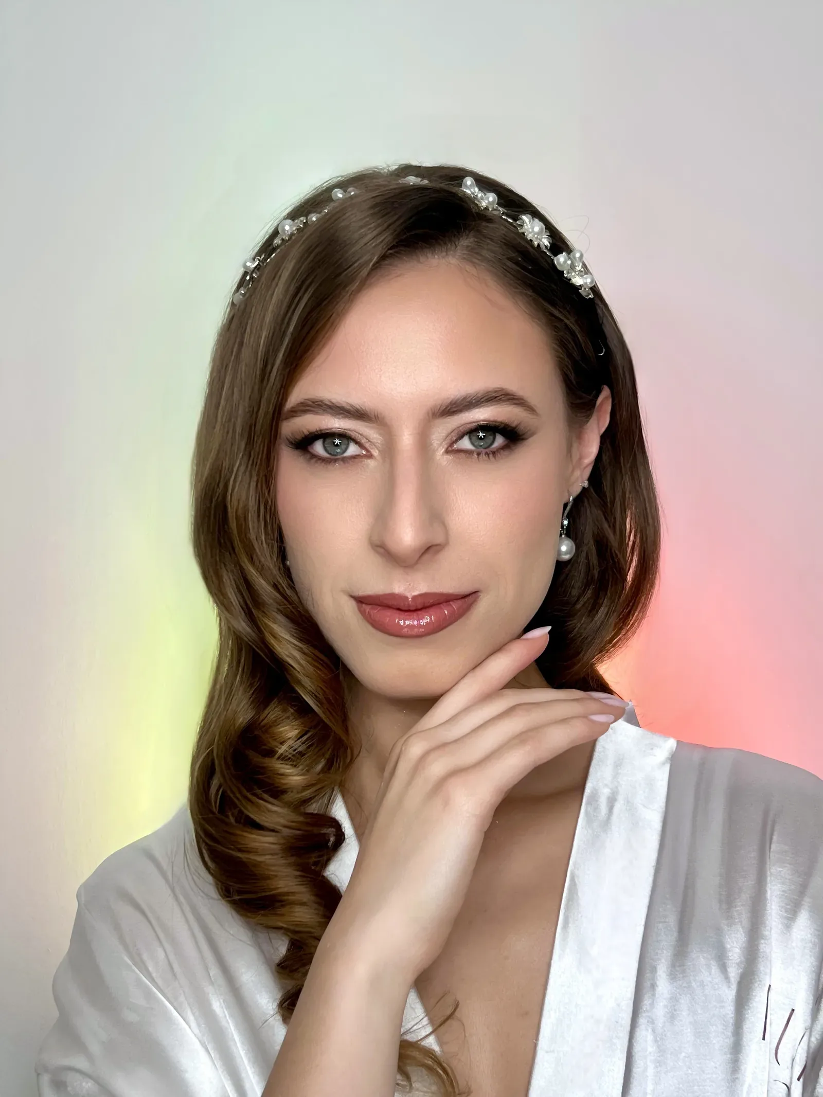Lau mira de frente con maquillaje de novia de delineado, piel luminosa y labios rosados, con tiara de perlas