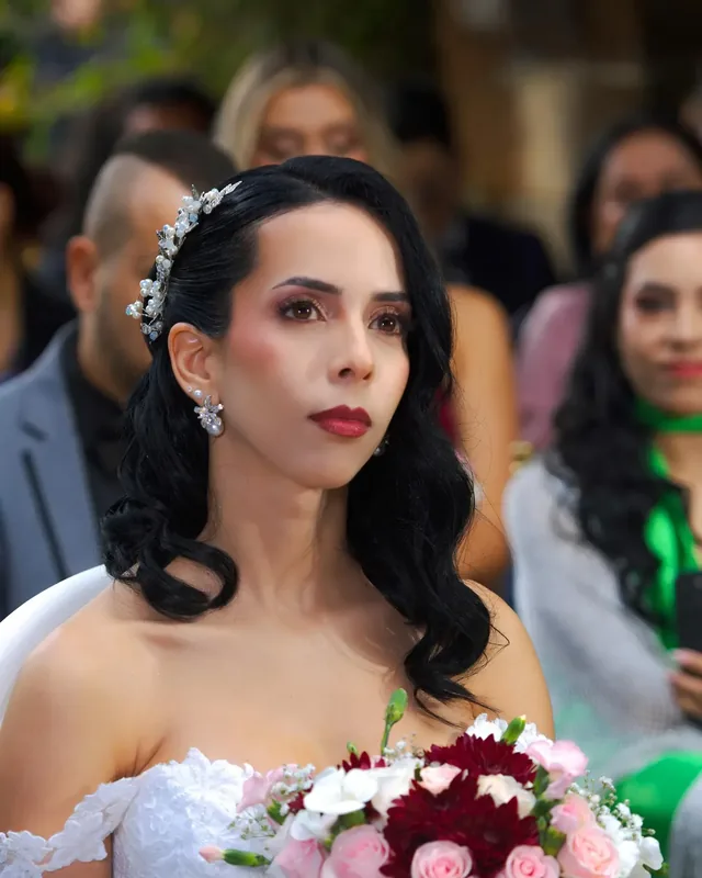 Laura con maquillaje de novia de labios rojos, sombra cobriza y ondas retro con tocado de perlas