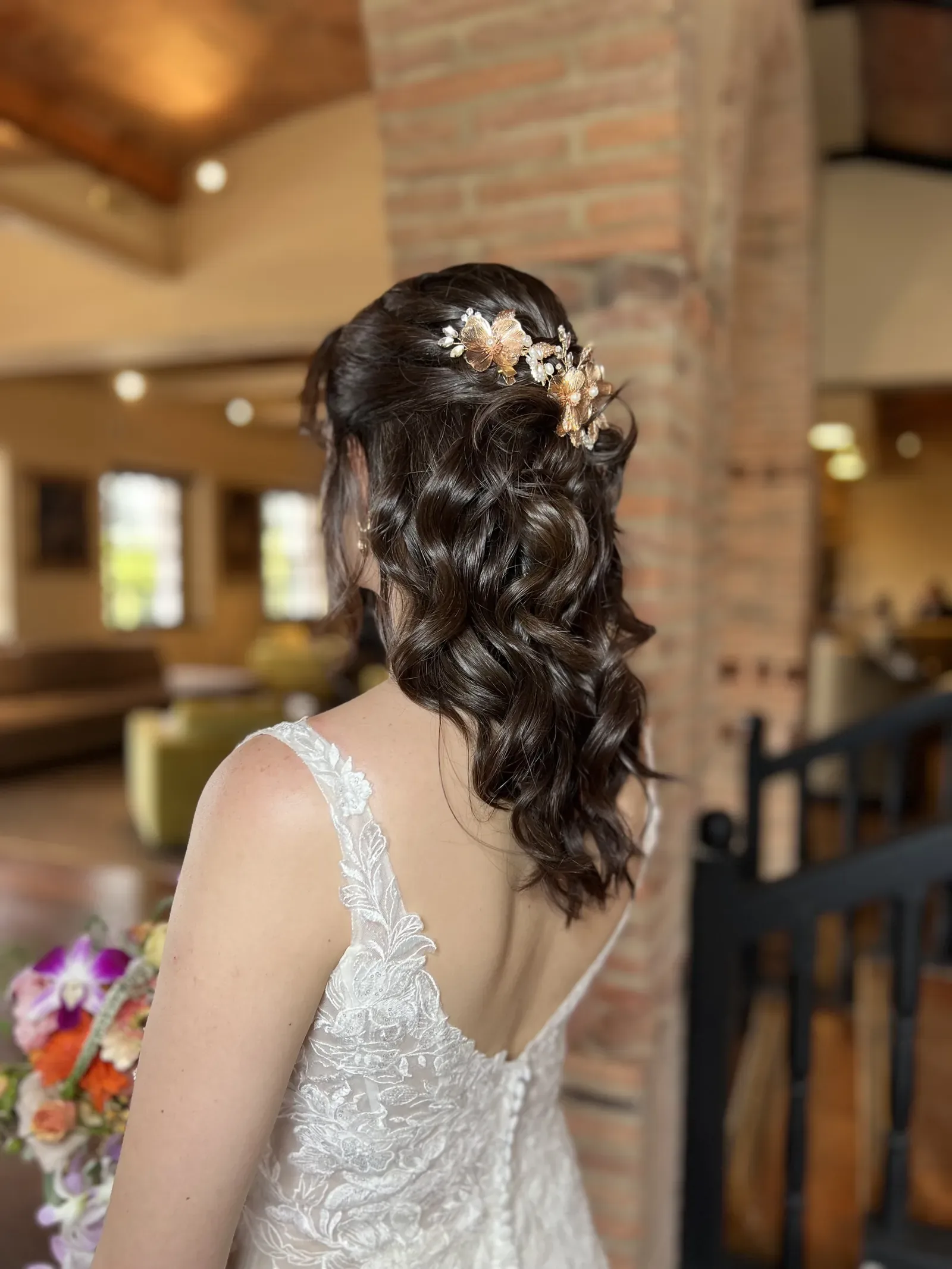 Peinado de novia de Laura: semirrecogido con ondas largas y tocado dorado de flores y perlas
