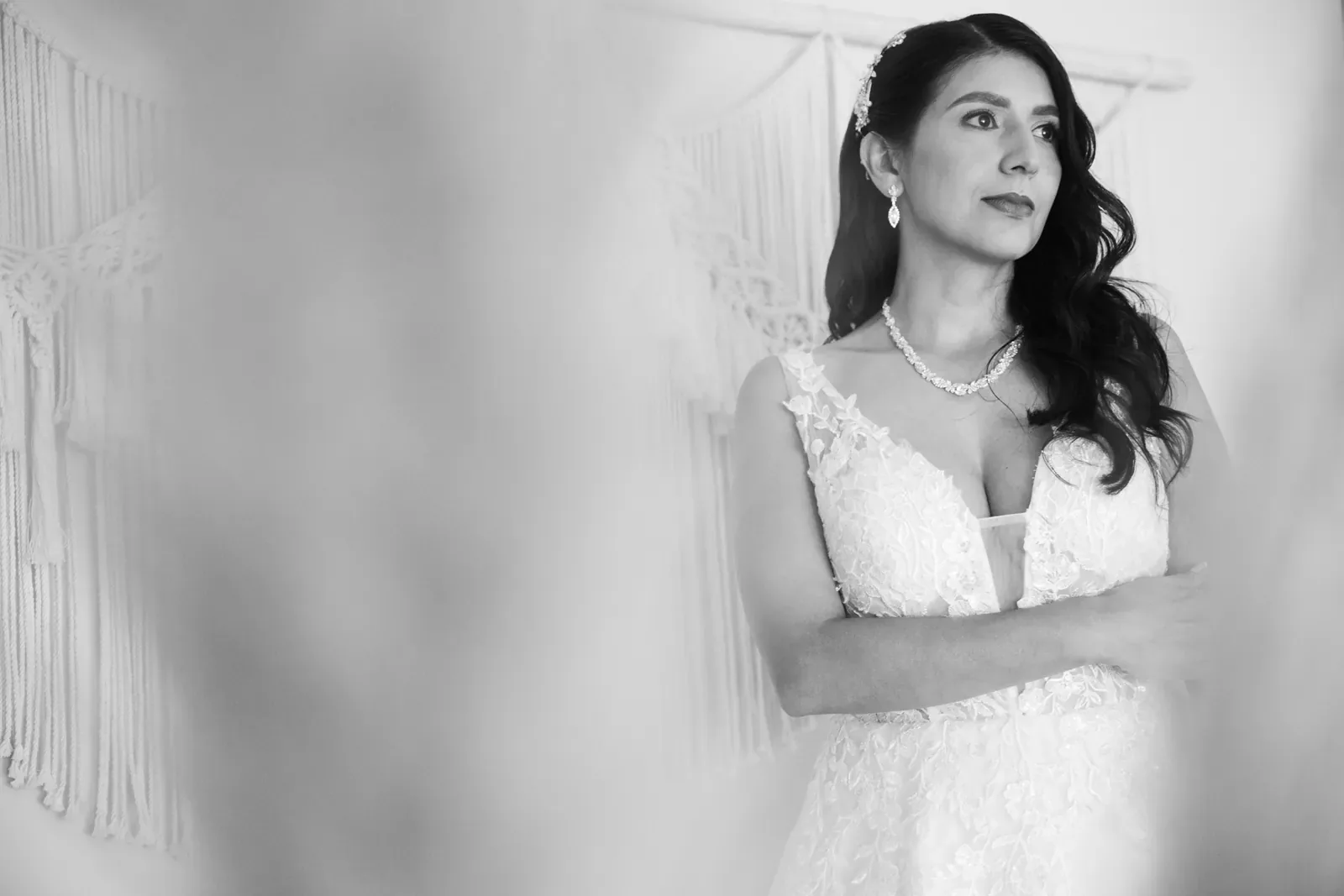 Luisa con maquillaje de novia, ondas laterales, tocado y aretes largos, en blanco y negro