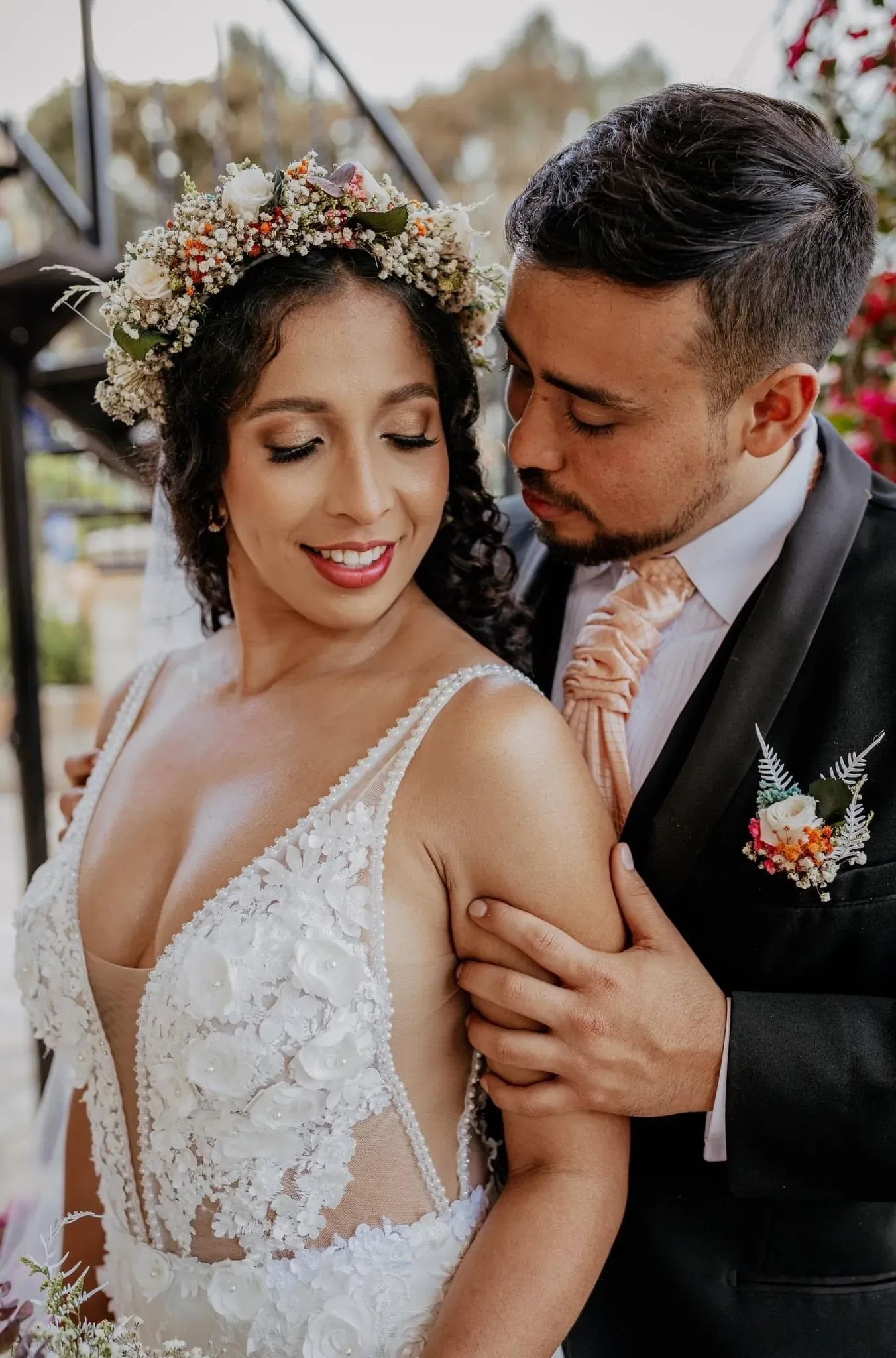 Stefa con los ojos cerrados y maquillaje de novia de sombra dorada, abrazada por el novio